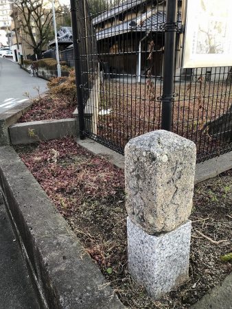旧新田小学校校舎のすぐそばにもあります。下部がなくなっていますが、「右　くま（のだ）〈熊野田〉」「左　大坂（道）」の文字。