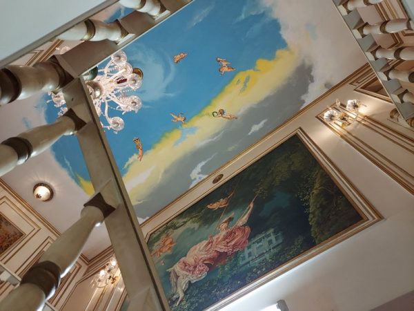 階段室の壁に描かれているのはフラゴナールの「ブランコ」の模写。天井画と一体化させるために、原画にない天使が描かれています。女性のドレスの後ろにはコーマル城が…。