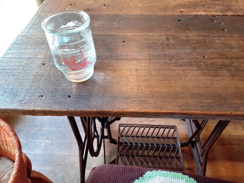 私が座った二人掛けテーブルの脚は古いミシン。レトロなガラスコップと最高の相性