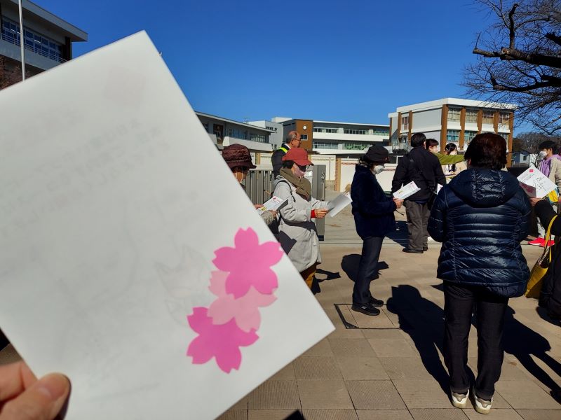 配布されたコースマップを眺める一般参加者たち。マップ表紙にはかわいい桜型の色紙があしらわれています。