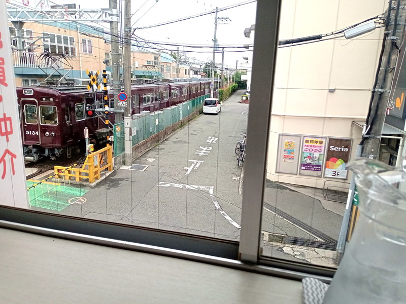 大きな窓ガラス越しに阪急電車が走る姿。外からの視線を気にせず通りの様子を眺められるのも上階だからこそ