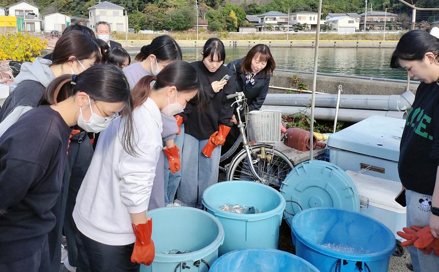 バケツいっぱいに漁獲された魚介類に興味津々です