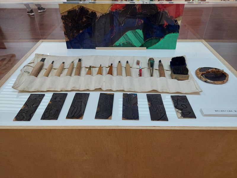 田中氏が制作に使用する道具と版木。「版画は紙を上げるまで成功か失敗かわからない。そのワクワクした気持ちがたまらない」と田中氏（森の美術館ホームぺージより）。