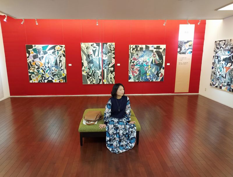 「田中里奈 木版画展」前期の赤壁の前で。筆者がこの日着ていたワンピースが、作品と妙に統一感があったので、おまけのショットです。