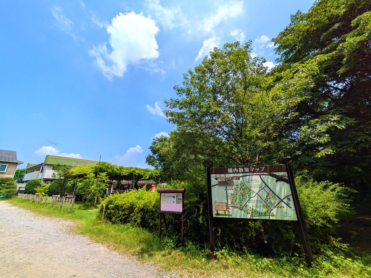 こんぶくろ池自然博物公園の入口を入って少し先にある園内図の横に謎が設置。写真左奥が管理棟。