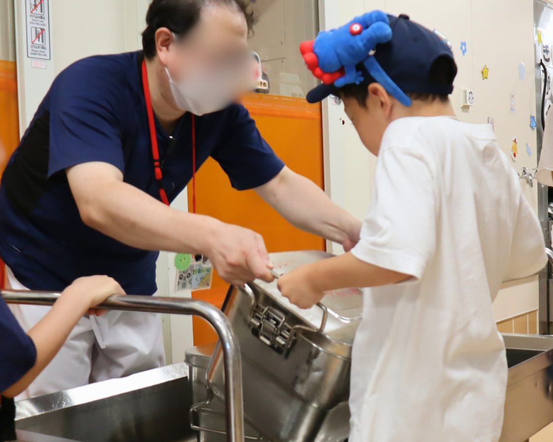 力いっぱい！重たい食缶を持ち上げます