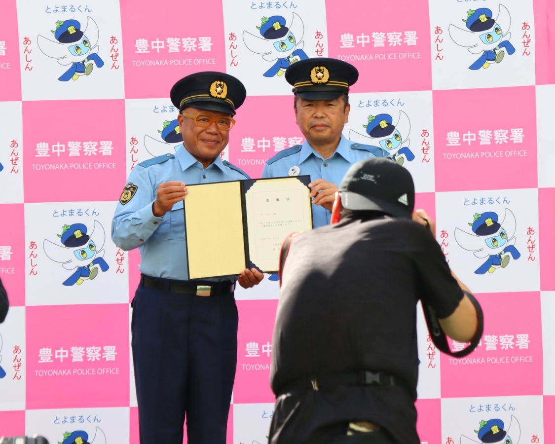 豊中警察署長さんから委任状を受け取るタージンさん