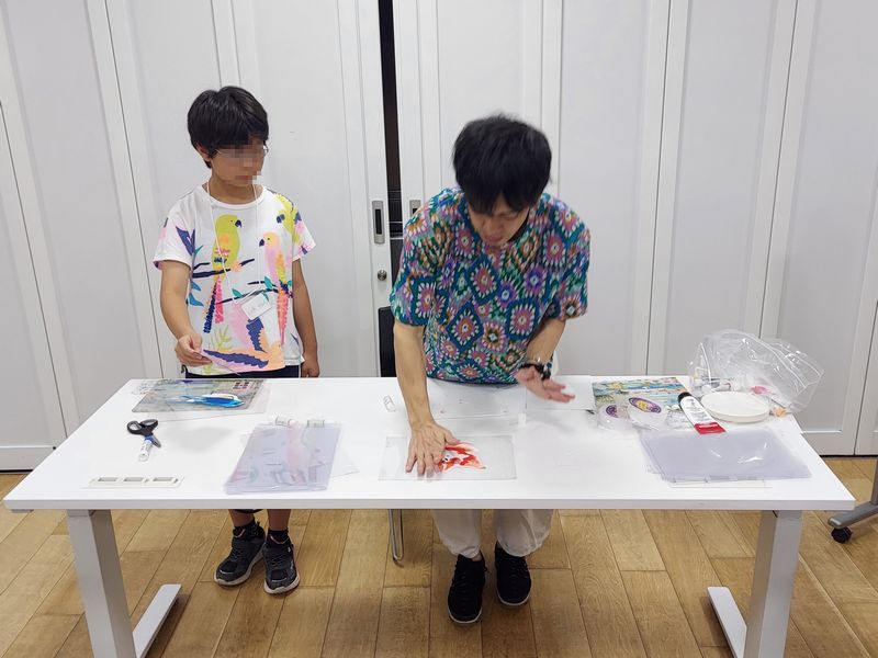 切り抜いた絵は、池平さんが透明な下敷きに貼っていきます。