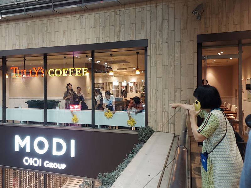 タリーズコーヒー客席への設置は、川上さんが携帯電話で細かく場所を指示しながら取り付けていきます。
