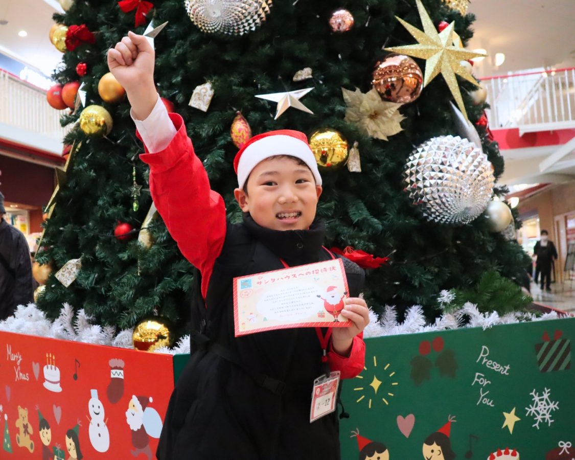 ツリーの前で、スタンプカードを手に「よし、行くぞ！」ここから小3の冒険がスタート。