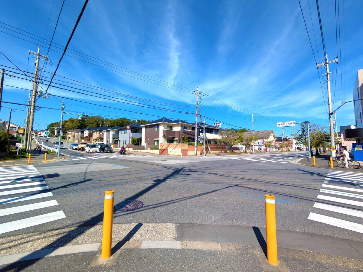 基幹道路の交差点。左奥の森は永楽台近隣公園。