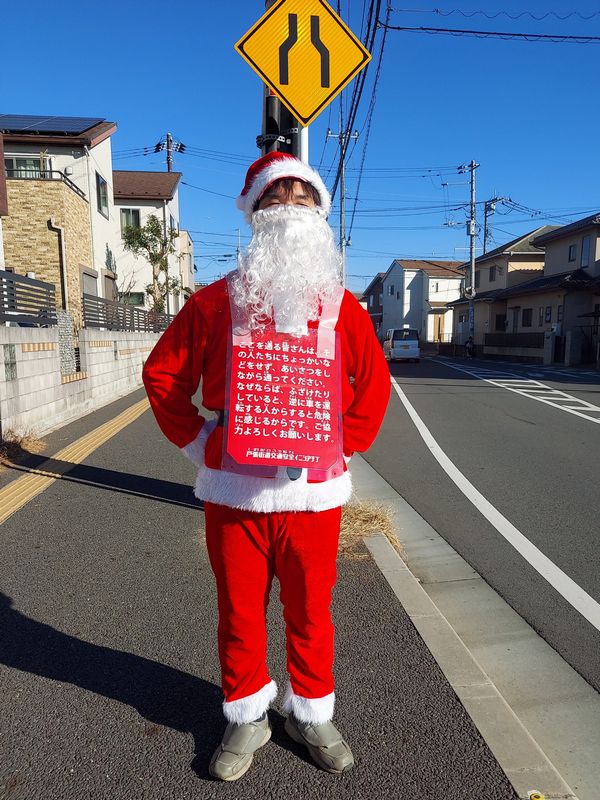 サンタのコスプレをした柏五小PTA地域安全副委員長・小齋さん。サンタのボディには通行する人向けに、この企画に関する注意書きが貼られています。