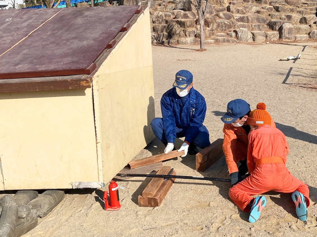 バールで小屋の下に隙間を作るところからスタート。 まずは道具をどう使うのか、全体の流れを教えてもらいます。