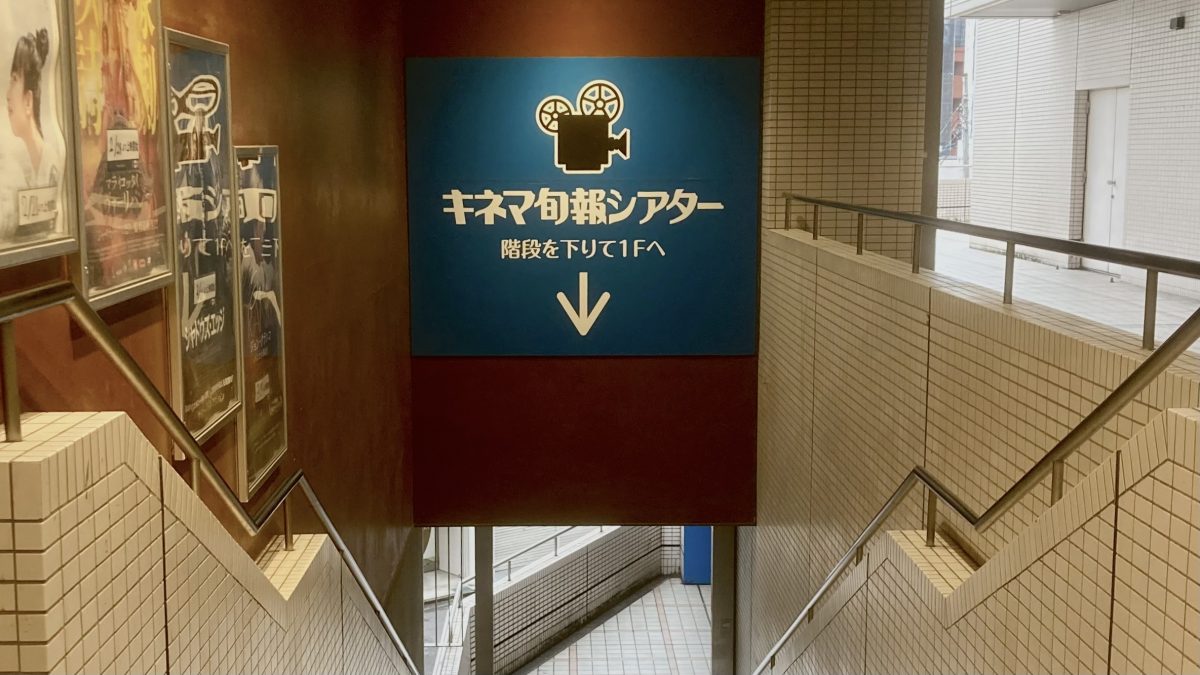 階段のポスターと青い看板を目印に…