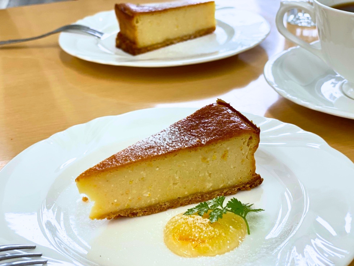 奥のケーキやコーヒーを背景に入れることで、カフェらしい雰囲気と奥行きのある一枚に。