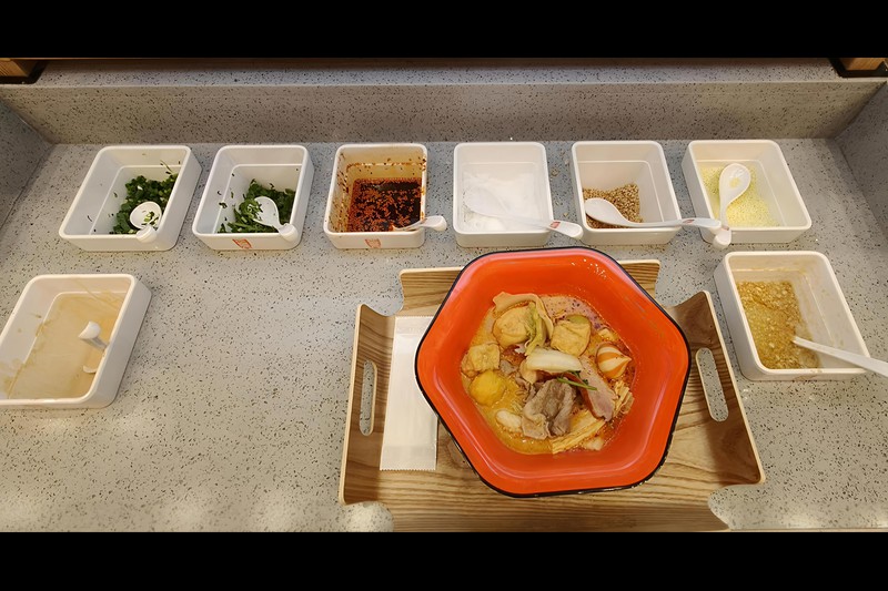 にんにくやわけぎ、胡麻だれやパクチー等々、たくさんの薬味が並ぶ