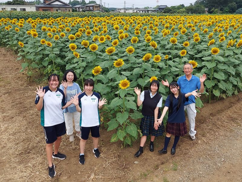 7月下旬に満開となったひまわりの前で記念撮影。たった2か月で畑一面に大きな花が咲きました!