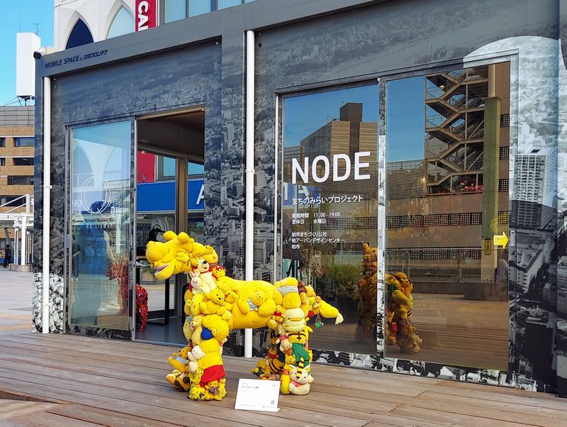 柏駅周辺まちづくり情報施設 NODE(柏駅東口ダブルデッキ)「ぬいぐるみ~ズ・黄馬」。よい子のみんなは、このぬいぐるみの馬に乗ってもOK! 建物の中にちらっと見えるのは「嘆きのメガロケロス・白角赤子」。