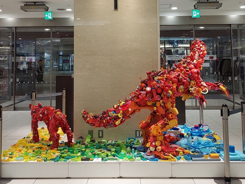 柏高島屋S館3階エントランス「トイザウルス・京睨み」(右)と「アンガードッグ・赤」(左)。ぜひ正面から、この赤い恐竜の圧倒的な迫力を感じてみてください。